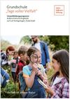 Kindergruppe, vorn stehen zwei Mädchen von denen eines durch eine Lupe schaut