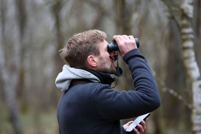 Mann mit Fernglas schaut in die Ferne