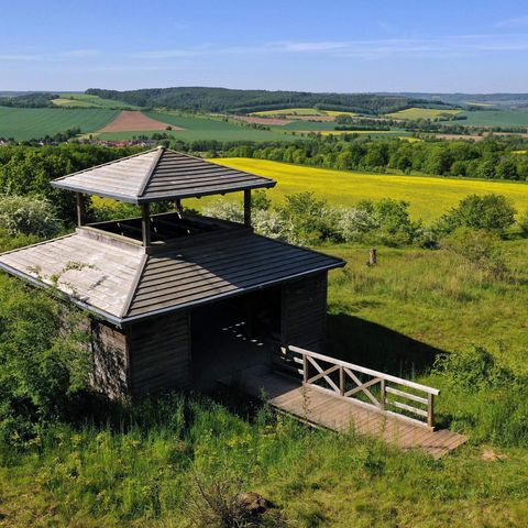 Hütte im Vordergrund in grün-gelber Landschaft