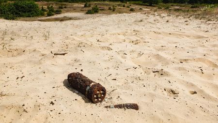 Der Wind hat einen rostigen Sprengkopf unter dem Sand einer Binnendüne freigelegt. 