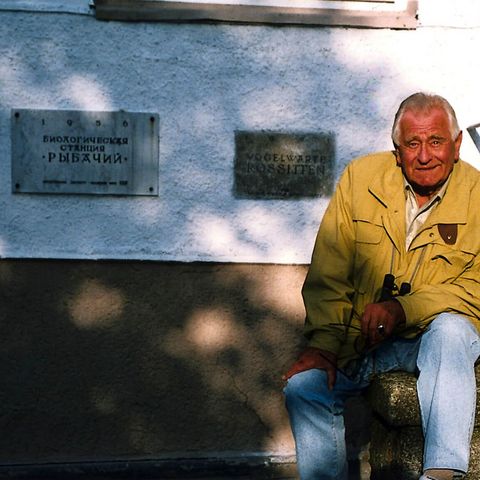 Heinz Sielmann sitzt vor dem Gebäude der Biologischen Station Rybatschi