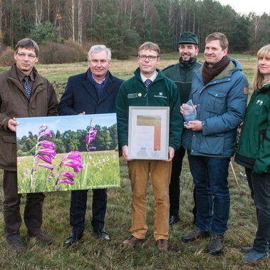 Siegerehrung auf der ausgezeichneten Gladiolenwiese im Daubaner Wald: (v.l.n.r.) Guido Puhlmann und Michael Beier überreichen Torsten Roch und seinem Team die Auszeichnung für Deutschlands schönste Wiese 2017. Foto: Bodo Hering / BROHT