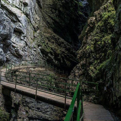 Ein Holzsteg führt durch hohe Felswände 