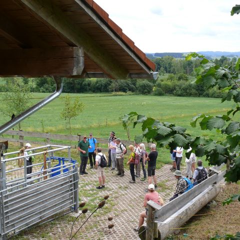 Menschen auf einem Bauernhof vor einem Stall