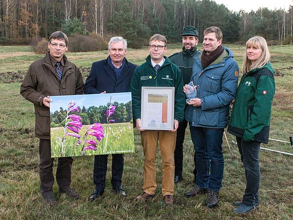 Siegerehrung auf der ausgezeichneten Gladiolenwiese im Daubaner Wald: (v.l.n.r.) Guido Puhlmann und Michael Beier überreichen Torsten Roch und seinem Team die Auszeichnung für Deutschlands schönste Wiese 2017. Foto: Bodo Hering / BROHT