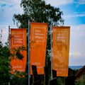 Drei orange Fahnen mit Logo der Heinz Sielmann Stiftung flattern im Wind
